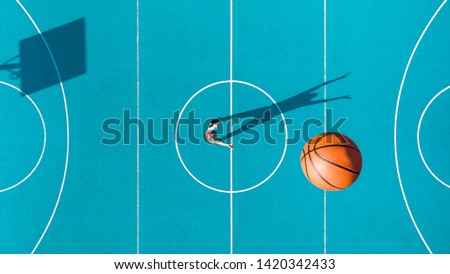 Basketball Player, Long Shadows on Basketball Court, Creative Visual Art, Aerial Image.