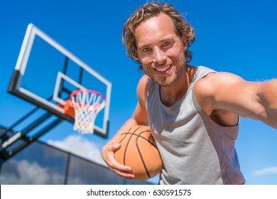 Basketball player man taking fun selfie photo at court net with basket ball. - Powered by Shutterstock