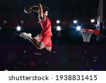 Basketball player in red uniform jumping high to make a slam dunk to the basket