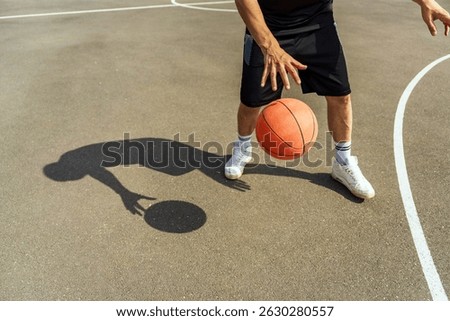 Basketball player showcasing skill while dribbling the ball on a sunny day at the local court