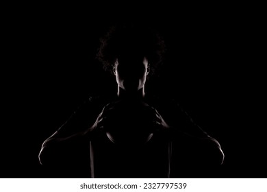 Basketball player silhouette holding a ball against black background. Side lit american man. - Powered by Shutterstock