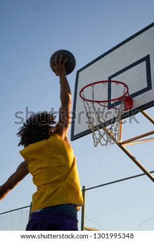 Similar – Foto Bild Junger männlicher Teenager spielt Basketball auf einem Platz im Freien.