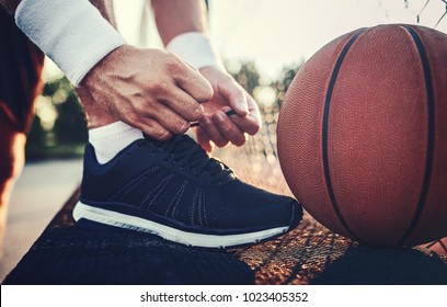 Basketball player tying sport shoes. Sport, recreation concept
