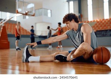 Basketball player warming up on the floor during sports training at school gymnasium.  - Powered by Shutterstock