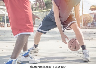 Basketball Players In Action On A Sunny Day In Open Court. African American Guys Playing Basketball Together. Close Up Shot With Motion Blur On Bouncing Ball