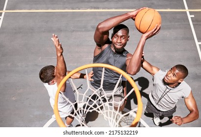 Basketball players blocking a player from dunking a ball into net to score points during a match on sports court from above . Fit athletes jumping to defend in competitive game for recreational fun - Powered by Shutterstock