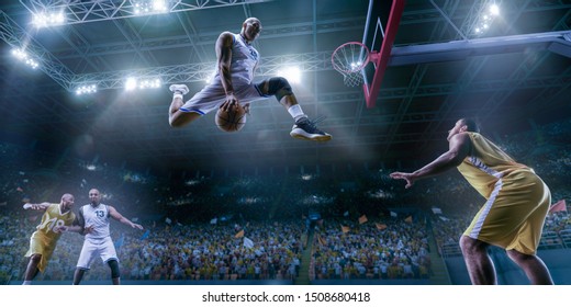 Basketball players on big professional arena during the game. Basketball player makes slam dunk. Bottom view