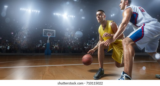 Basketball players on big professional arena during the game. Players fight for the ball. 