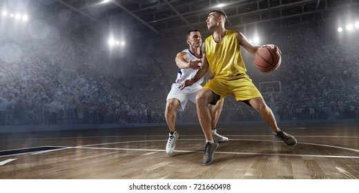 Basketball players on big professional arena during the game. Players fight for the ball. Players wearing unbranded clothes.
