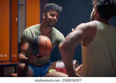 Basketball players sitting on bench facing each other and having a great conversation after workout, young man explaining something to his friend. - Powered by Shutterstock