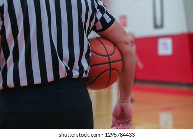 A Basketball Referee Holds A Ball During A Timeout