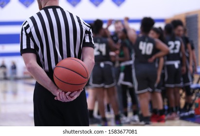 A basketball referee holds a ball during a timeout. - Powered by Shutterstock