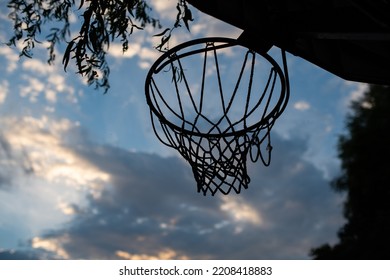 Basketball Ring Or Hoop In A Yard. Low Angle Shot, Blue Summer Sky In The Background, No People.