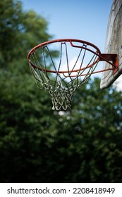 Basketball Ring Or Hoop In A Yard. Low Angle Shot, Blue Summer Sky In The Background, No People