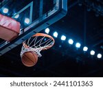 Basketball scoring a basket as it goes through the hoop and making a swish in the net