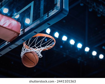 Basketball scoring a basket as it goes through the hoop and making a swish in the net