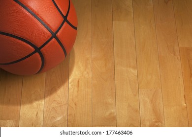 Basketball With Spot Lighting On A Wood Gym Floor