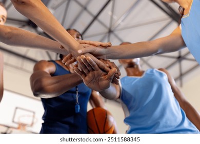 Basketball team huddling together, showing unity and teamwork in gym. sports, athletes, motivation, competition, huddle - Powered by Shutterstock