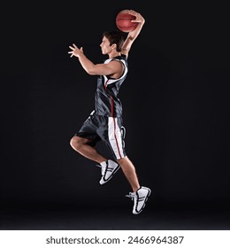 Basketball, training and man jump in studio for exercise, energy and healthy body fitness. Sports, player and athlete shooting ball for competition, game and mockup space isolated on black background - Powered by Shutterstock