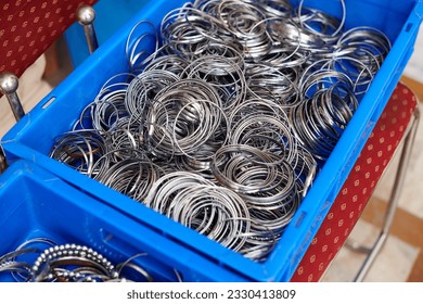 Baskets with batch of kara sikh bangles for sale in Gurudwara Bangla Sahib temple, many steel bracelets shopping for tourists, kara bangles symbol of unbreakable attachment and commitment to God