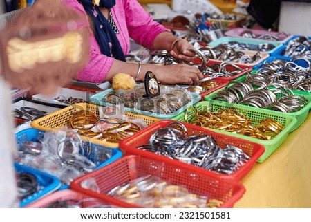 Baskets with batch of kara sikh bangles for sale in Gurudwara Bangla Sahib temple, many steel bracelets shopping for tourists, kara bangles symbol of unbreakable attachment and commitment to God
