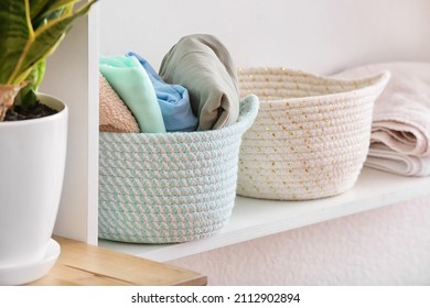 Baskets with clean clothes on shelf, closeup