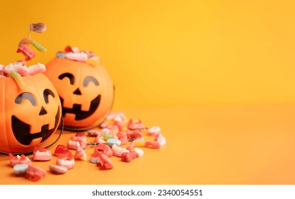 Baskets in the form of pumpkins with sweets on yellow background. - Powered by Shutterstock