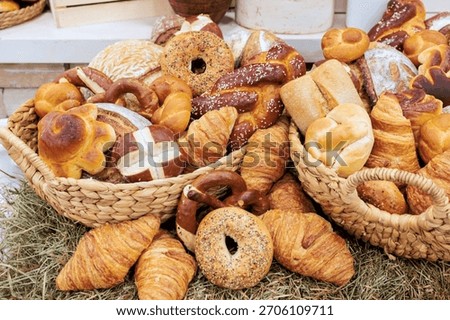 Baskets overflowing with different kinds of bread variety of shapes in local bakery setting.