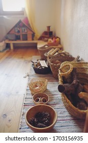 Baskets with wooden toys from Waldorf pedagogy and a wooden house.