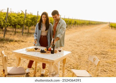 Basking in the warm sunlight, a joyful couple embraces as they revel in a delightful picnic among the grapevines, savoring wine and gourmet treats - Powered by Shutterstock