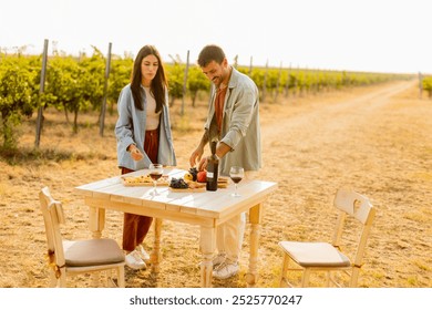 Basking in the warm sunlight, a joyful couple embraces as they revel in a delightful picnic among the grapevines, savoring wine and gourmet treats - Powered by Shutterstock