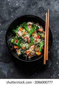 Basmati rice with shrimp and vegetables in asian style on a dark background, top view