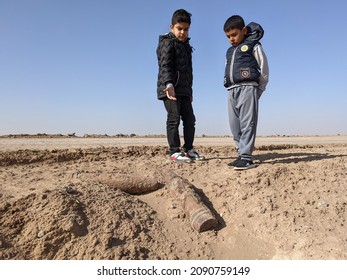 basra, iraq - december 10, 2021: photo of kids playing near unexplode mortar gun shells in Iraq