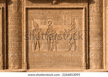 Bas-relief with hieroglyphs and the image of the gods and Emperor Trajan on the wall of the ancient Roman mammisi, Compex Temple of Dendera, Egypt.