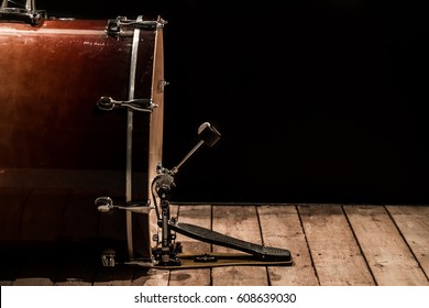 Bass Drum With Pedal On Wooden Floor With A Black Background