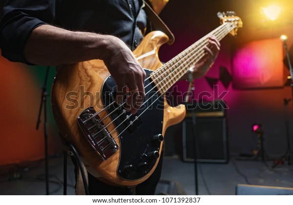 bass guitar in hands of\
musician