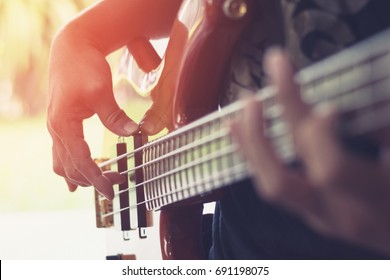 Bass Guitar Player Or Guitarist Playing Music Instrument (focus On Hand)