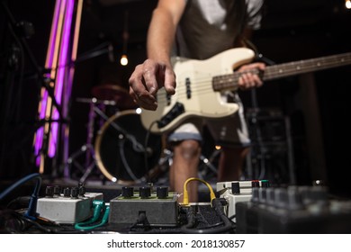 Bass guitar player on a stage with set of distortion effect pedals. - Powered by Shutterstock