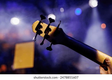 Bass guitar tuning pegs close-up view during a music group performance - Powered by Shutterstock