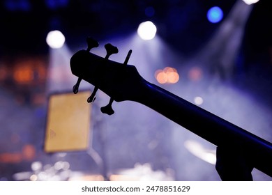 Bass guitar tuning pegs close-up view during a music group performance - Powered by Shutterstock