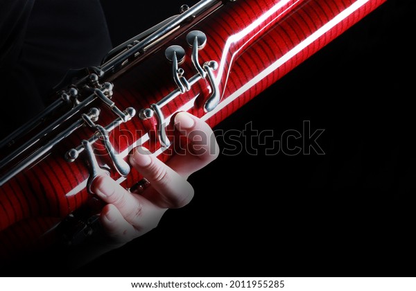 Bassoon woodwind instrument with\
player hand details. Orchestra musical instruments close\
up