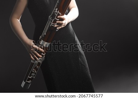 Bassoon woodwind instrument with player hands. Orchestra musical instruments close up