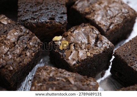 
Batch of chocolate brownies (likely walnut brownies).
Dark, fudgy texture with that classic crinkly top layer typical of brownies.
Square-cut pieces.
Visible nut pieces (probably walnuts or pecans) mixed in.
Brownies are a rich, dense American chocolate dessert, usually made with chocolate, butter, sugar, eggs, and flour (often with minimal flour for a fudgier result).