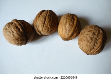 Batch Of Four Ripe Brown Rounded Wrinkly Fruits Of Persian Walnut