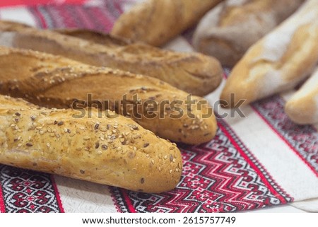 A batch of fresh baked bread lies on a Ukrainian towel. Food