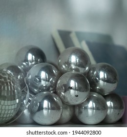 A batch of glass balls with reflections and a mirror ball as New Year decor or Christmas tree decoration. End of season. Shiny silver color metallic texture. Geometric shape. - Powered by Shutterstock