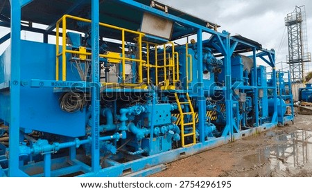 Batch mixer cementing unit used in oil and gas operation, featuring dual mixing tanks on both sides with a central engine and operator console designed for reliable cement preparation during projects.