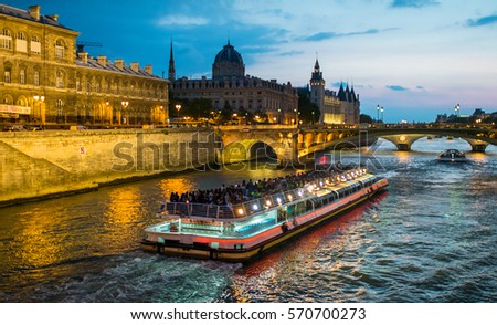 Bateau Mouche cruising on Seine river at sunset, Paris.