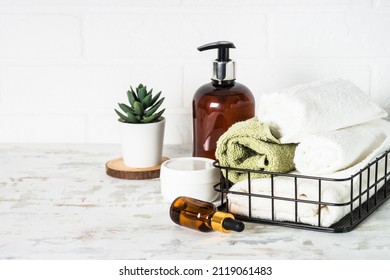 Bath accessories. Bottle of soap, cream, serum and towels - Shutterstock ID 2119061483