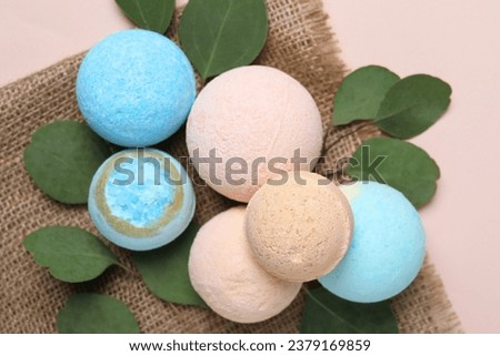 Bath bombs, eucalyptus leaves and burlap fabric on beige background, flat lay